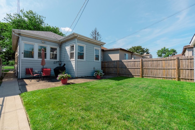 back of property with a patio area and a lawn