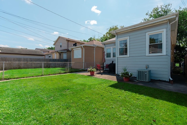 rear view of house with a lawn, a patio area, and cooling unit