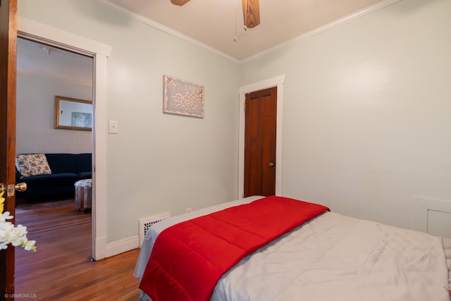 bedroom featuring hardwood / wood-style floors, ceiling fan, and crown molding