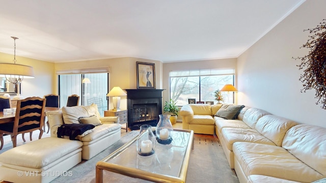 carpeted living area featuring a glass covered fireplace and ornamental molding