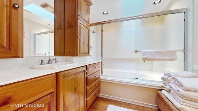 full bathroom featuring visible vents, wood finished floors, recessed lighting, shower / bath combination with glass door, and vanity