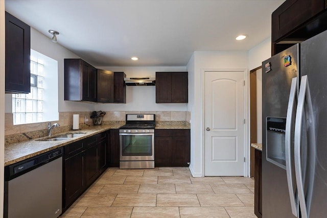 kitchen featuring light stone countertops, sink, extractor fan, dark brown cabinets, and appliances with stainless steel finishes