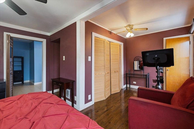 bedroom featuring hardwood / wood-style flooring, ceiling fan, connected bathroom, ornamental molding, and a closet