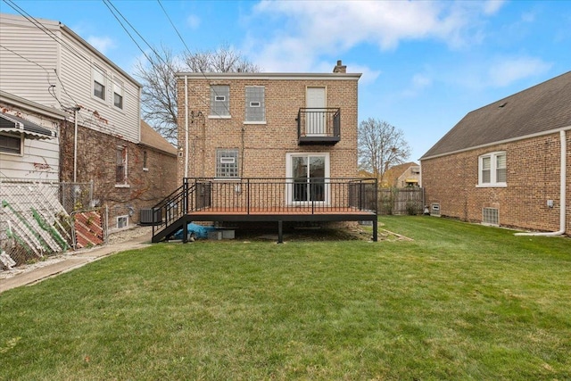 rear view of house with a wooden deck and a yard