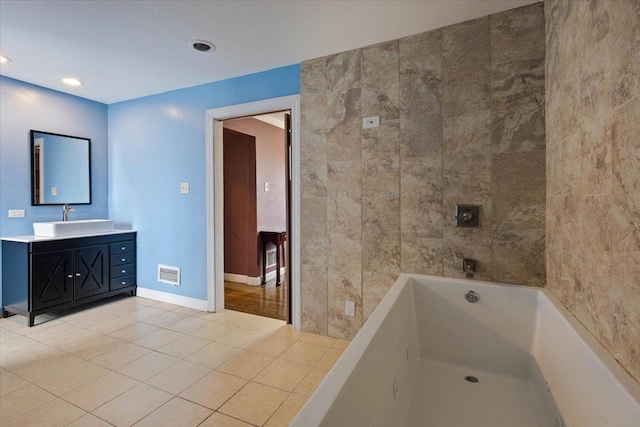 bathroom with tile patterned floors, vanity, and a tub to relax in