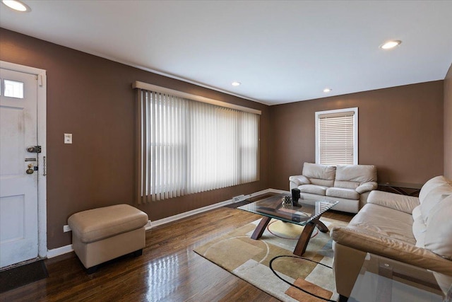 living room with dark wood-type flooring and a wealth of natural light