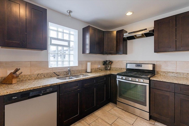 kitchen with stainless steel appliances, light stone countertops, dark brown cabinets, and sink