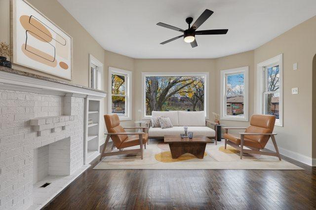 interior space with hardwood / wood-style flooring, a brick fireplace, and ceiling fan