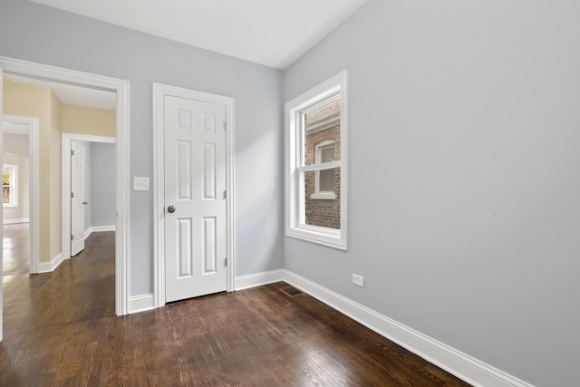 empty room with dark wood-type flooring