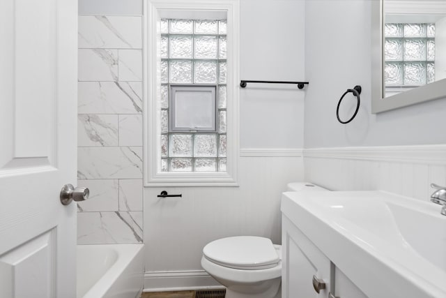 bathroom featuring plenty of natural light, tiled shower / bath combo, and toilet