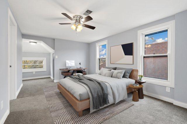 carpeted bedroom with multiple windows and ceiling fan