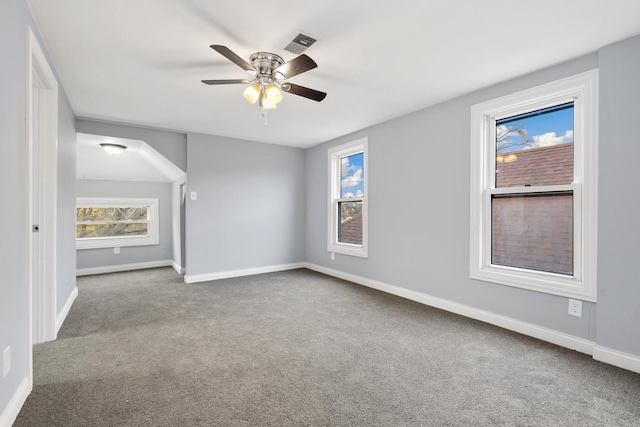 carpeted empty room featuring ceiling fan and a healthy amount of sunlight