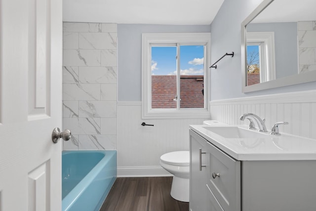 bathroom featuring hardwood / wood-style flooring, a washtub, toilet, and vanity