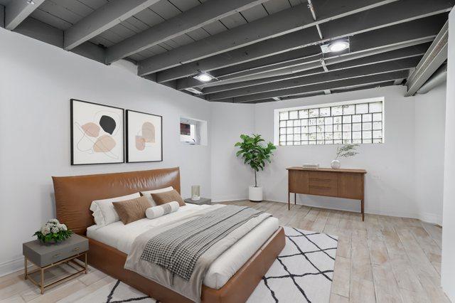 bedroom with beamed ceiling and light hardwood / wood-style floors