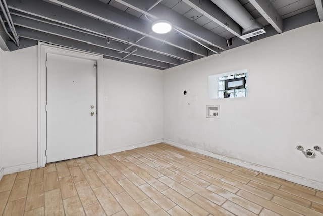 basement with light hardwood / wood-style flooring