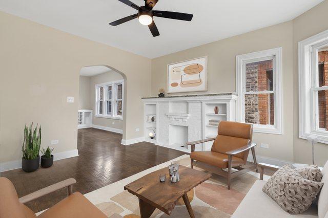 living room with ceiling fan, a fireplace, and hardwood / wood-style flooring