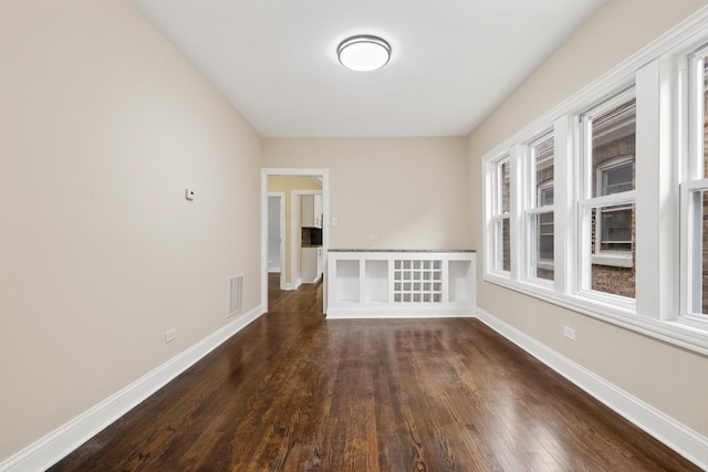 empty room with dark hardwood / wood-style flooring