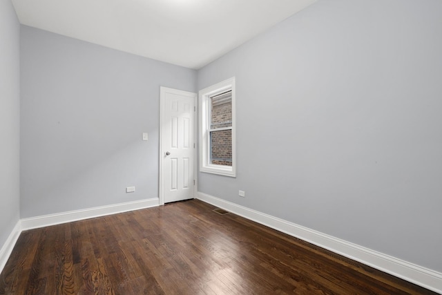 empty room with dark hardwood / wood-style flooring