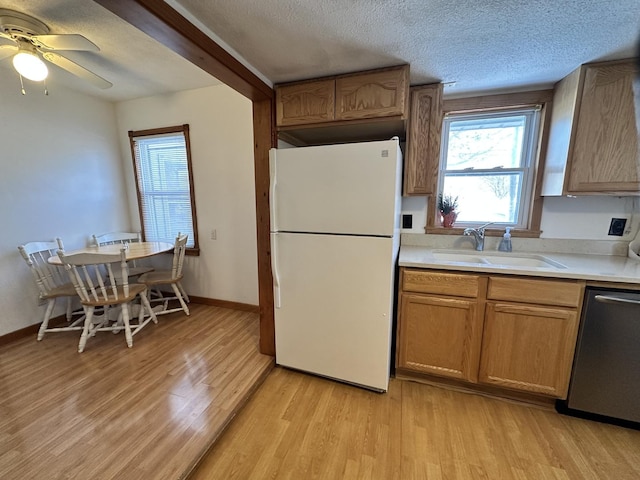 kitchen with a textured ceiling, sink, white refrigerator, light hardwood / wood-style flooring, and dishwasher