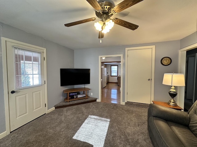 carpeted living room with ceiling fan