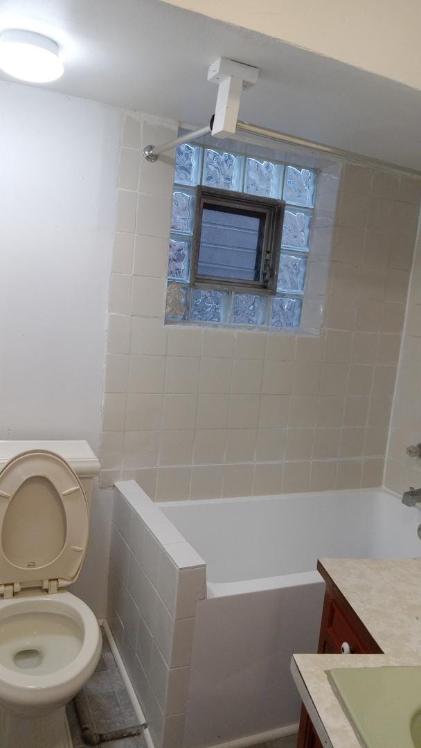 full bathroom with vanity, toilet, and tiled shower / bath combo