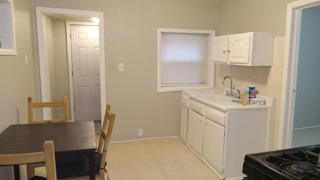 kitchen featuring white cabinetry, sink, and black range with gas cooktop