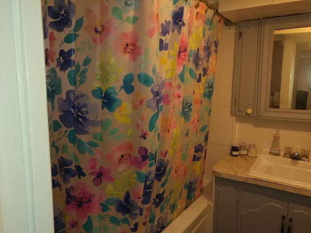 bathroom featuring shower / bath combo, backsplash, and vanity