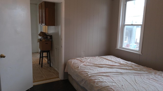 bedroom featuring multiple windows and wooden walls