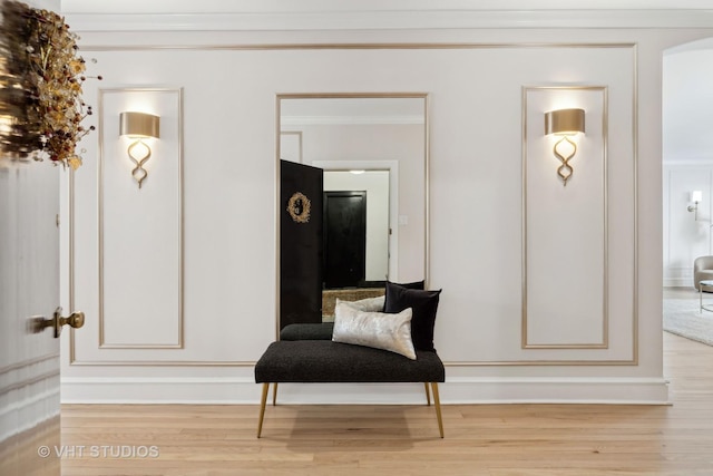 sitting room featuring ornamental molding and light hardwood / wood-style flooring