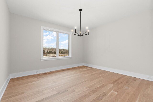 kitchen with wall chimney range hood, light wood finished floors, appliances with stainless steel finishes, and a sink