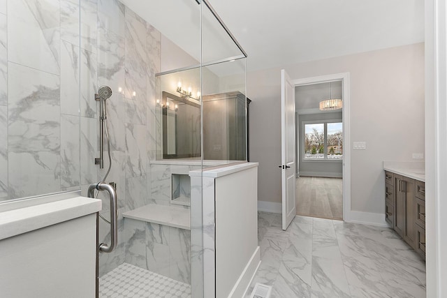 bathroom featuring visible vents, marble finish floor, a marble finish shower, baseboards, and vanity