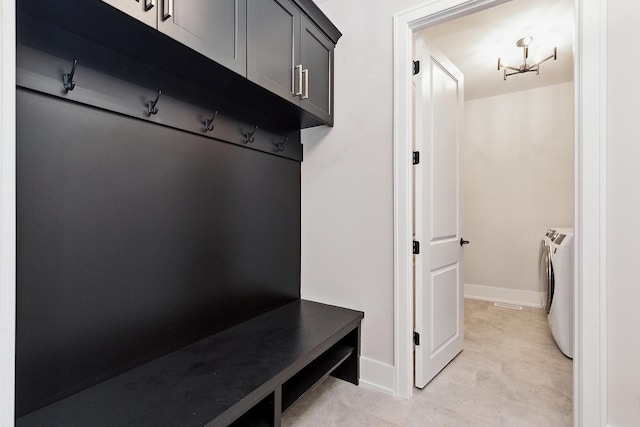 mudroom featuring washer and dryer, baseboards, and a chandelier