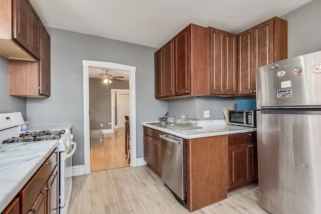 kitchen with ceiling fan, light hardwood / wood-style flooring, sink, and appliances with stainless steel finishes