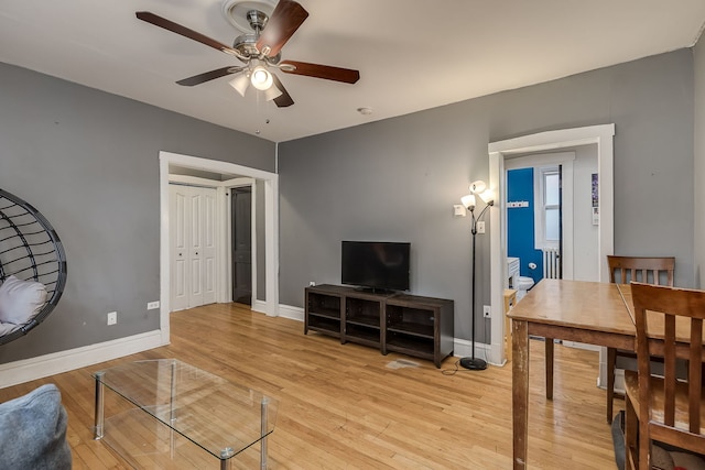 living room featuring ceiling fan and light hardwood / wood-style floors