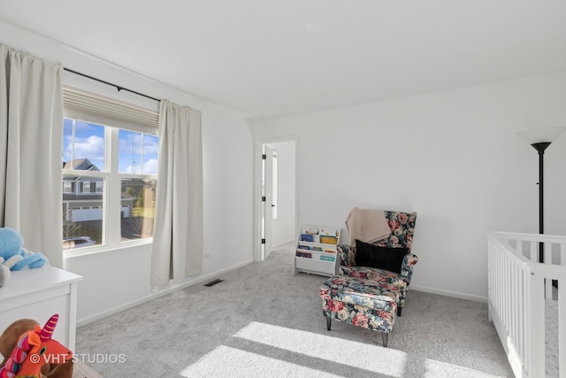 bedroom featuring light carpet and a nursery area