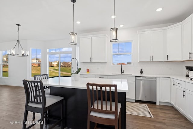 kitchen with dishwasher, white cabinets, a kitchen island, and hanging light fixtures