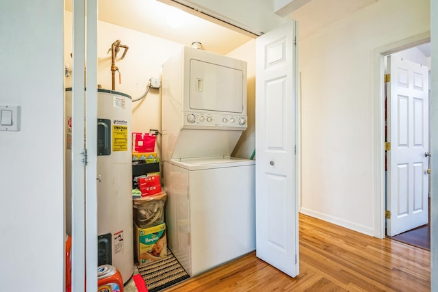 washroom featuring light hardwood / wood-style floors, electric water heater, and stacked washer / dryer