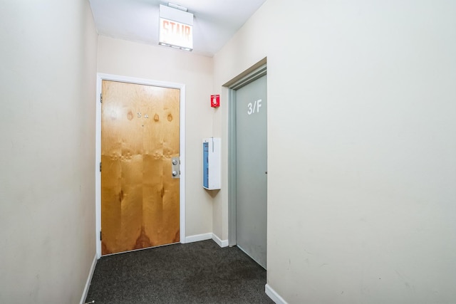 entryway with dark carpet