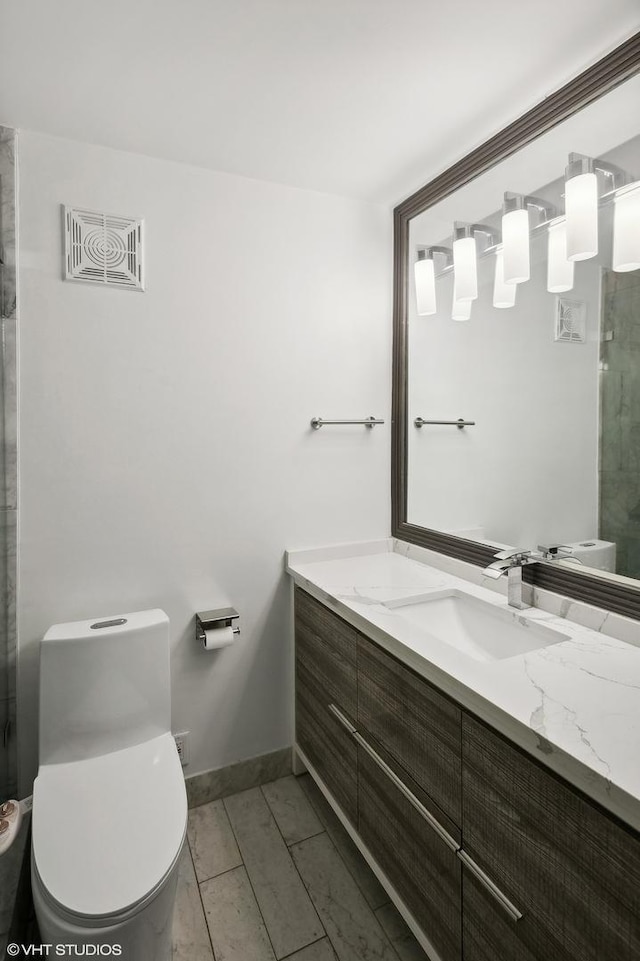 bathroom featuring vanity, toilet, and a shower with shower door