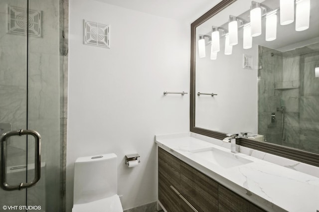 bathroom with an enclosed shower, vanity, and toilet