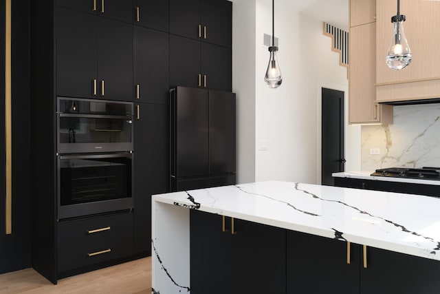 kitchen with backsplash, light hardwood / wood-style flooring, pendant lighting, and appliances with stainless steel finishes