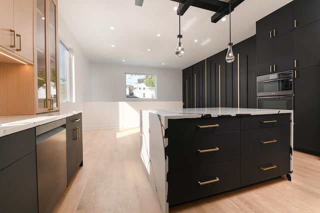 kitchen with light hardwood / wood-style flooring, a kitchen island, decorative light fixtures, and appliances with stainless steel finishes