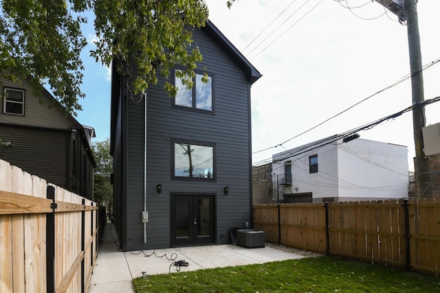 rear view of house with central air condition unit, a yard, and a patio