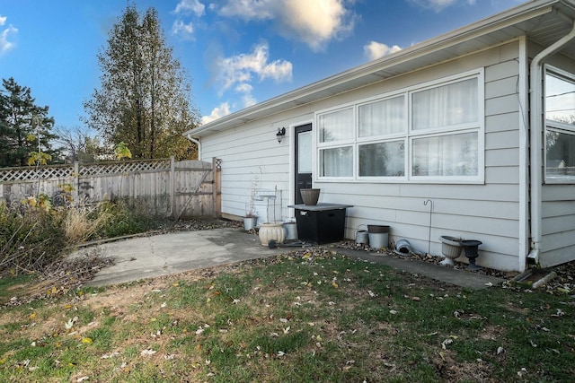 back of house with a lawn and a patio