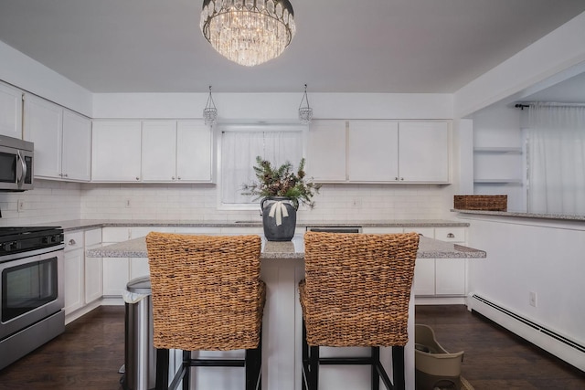 kitchen featuring a kitchen breakfast bar, white cabinetry, appliances with stainless steel finishes, and a baseboard radiator