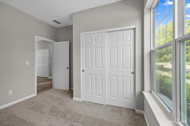 unfurnished bedroom featuring carpet flooring and a closet