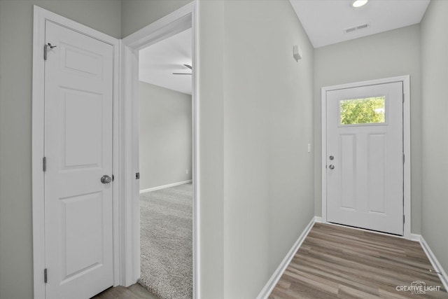 doorway with light wood-type flooring and ceiling fan