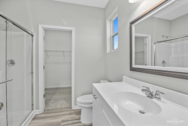 bathroom with vanity, hardwood / wood-style flooring, toilet, and an enclosed shower