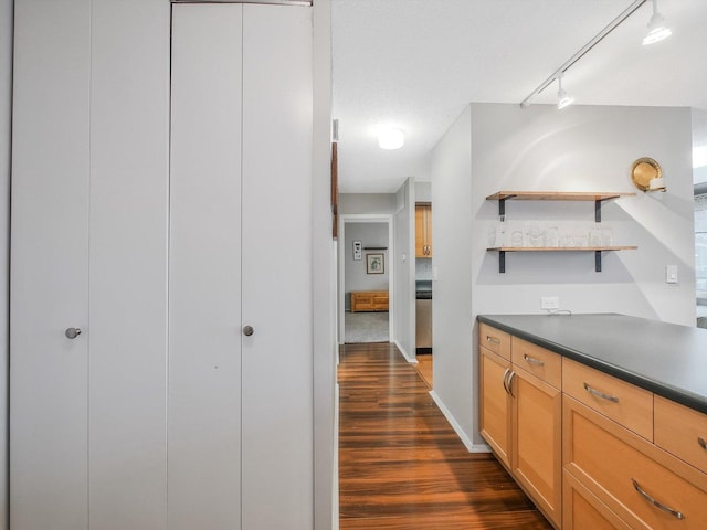 interior space featuring a textured ceiling, rail lighting, and dark hardwood / wood-style floors