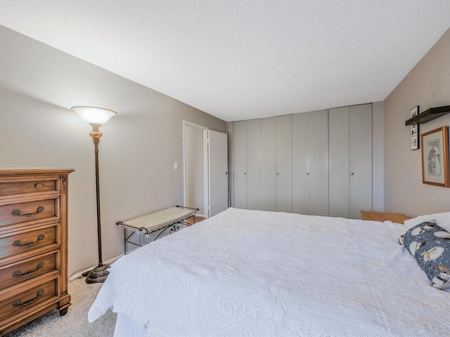 bedroom featuring light colored carpet and a textured ceiling